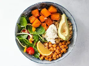 A vibrant Buddha bowl with roasted pumpkin, avocado, chickpeas, quinoa, lemon and fresh greens